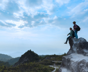 People sitting on a tall rock