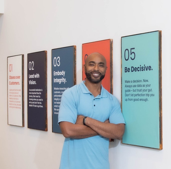 Person leaning against a wall where our nine core beliefs are framed and on display