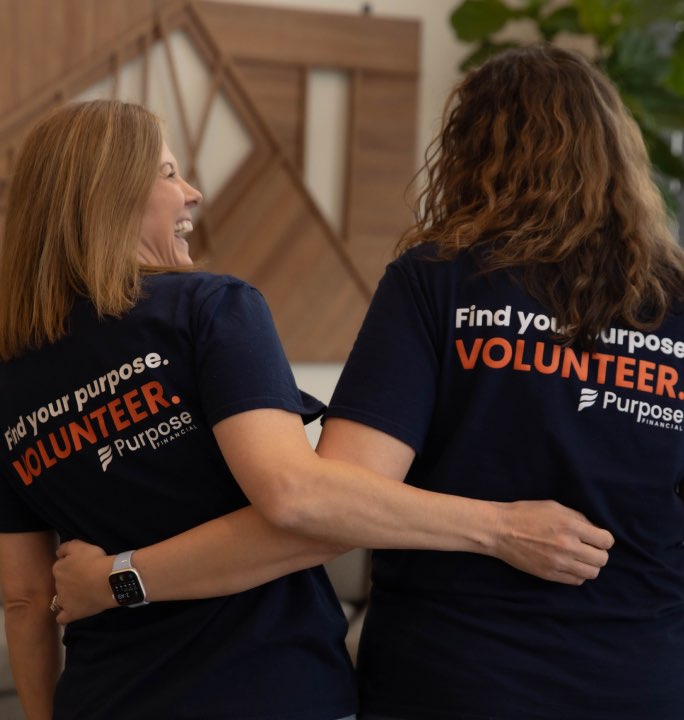 Two Purpose Financial team members volunteering in the community and laughing together